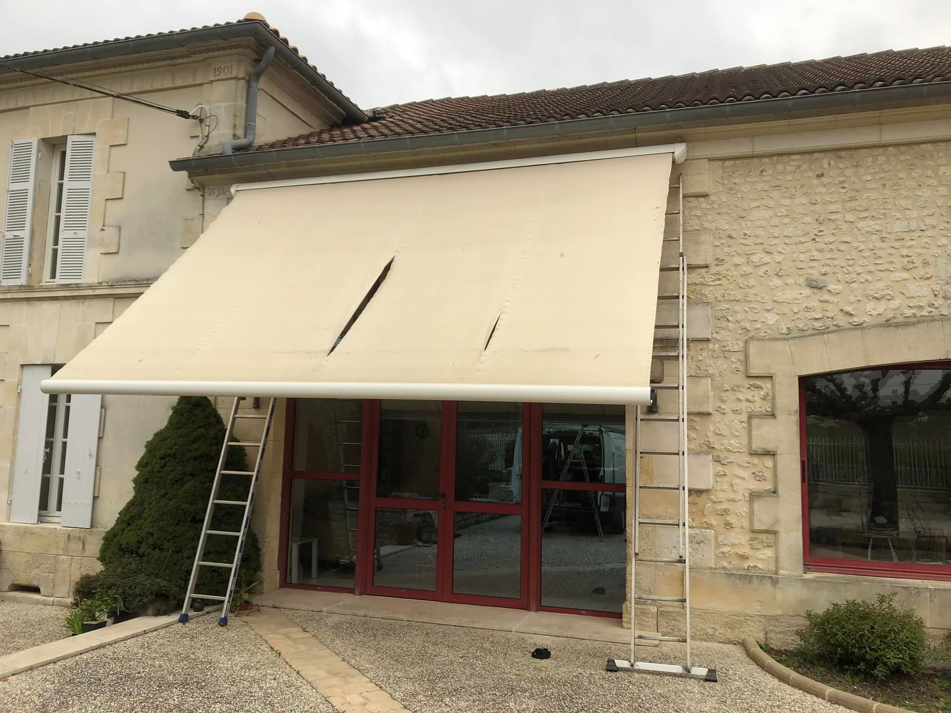 Un store de devanture beige abîmé