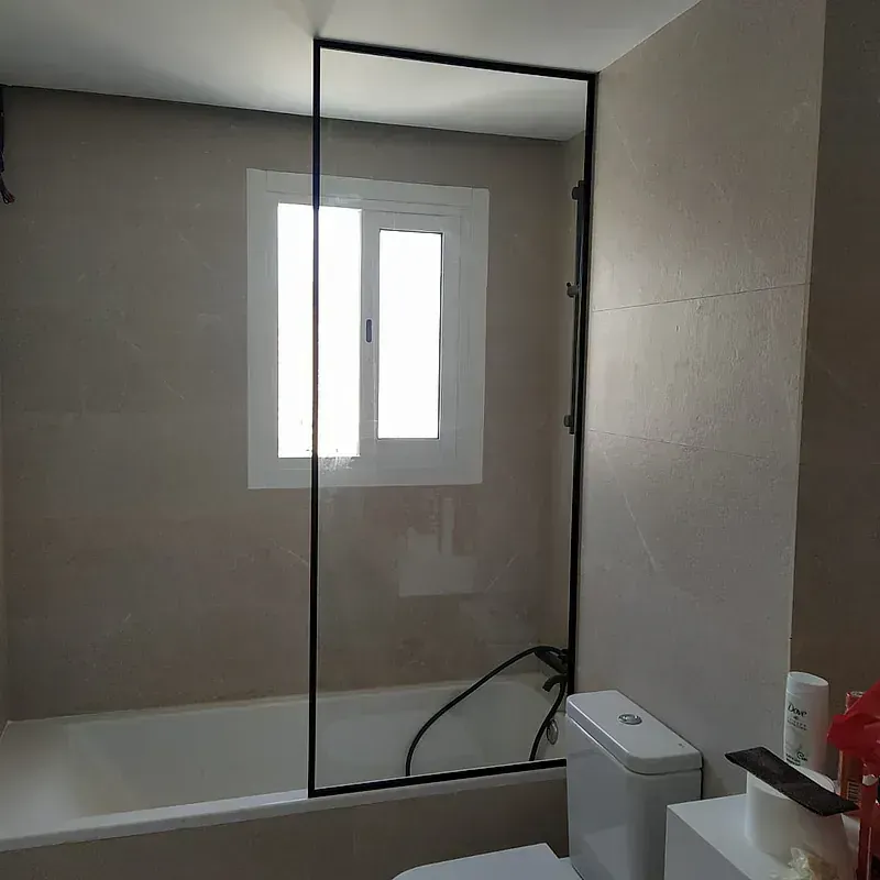 Un baño con bañera, inodoro, espejo y ventana.