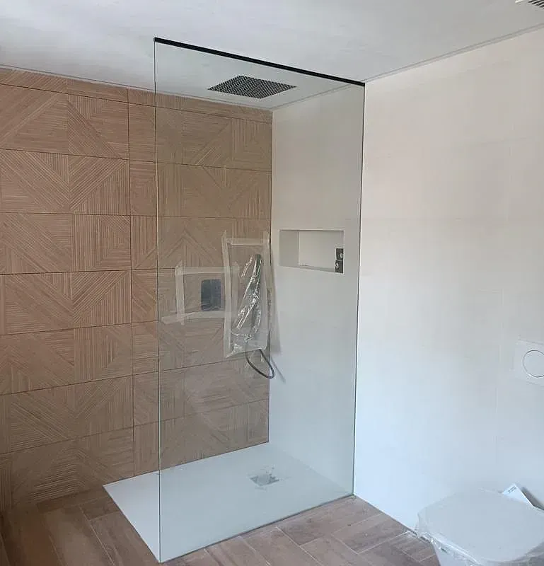 Un baño con ducha a ras de suelo y un inodoro.