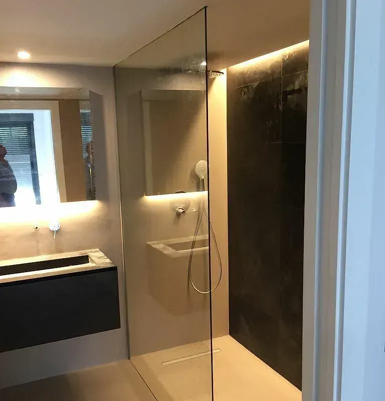 Un baño con ducha, lavabo y espejo.