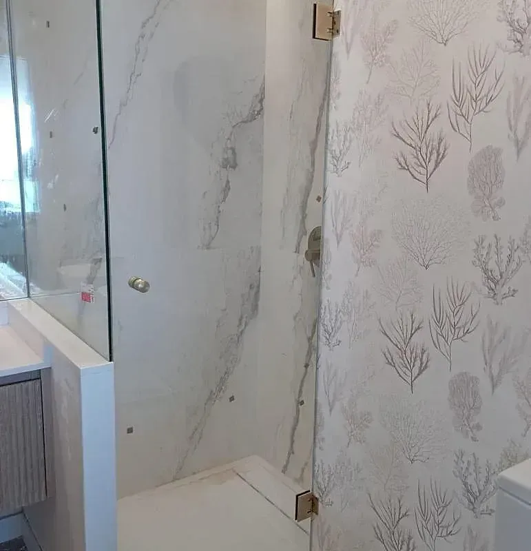 Un baño con puerta de ducha de cristal y un inodoro.