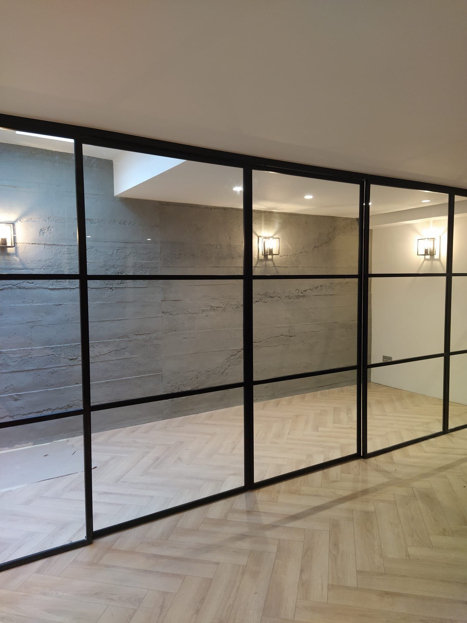 Una habitación con muchas ventanas y suelo de madera.