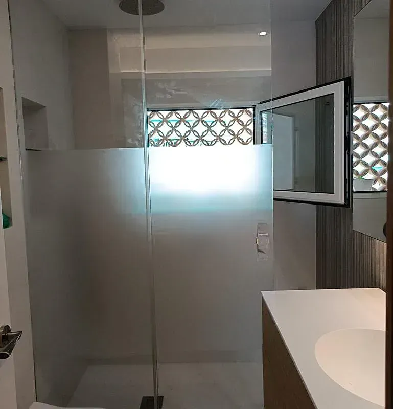 Un baño con puerta de ducha de cristal y lavabo.