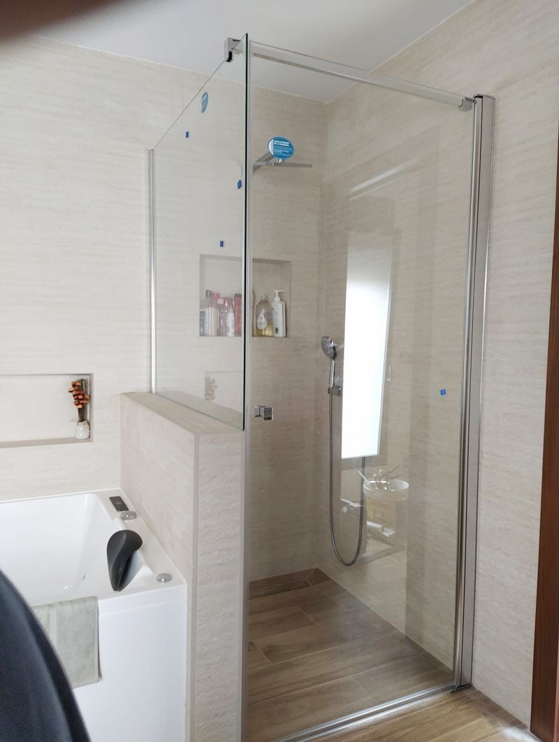 Un baño con ducha a ras de suelo y bañera.