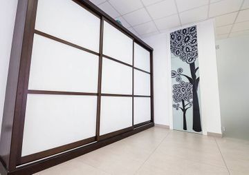 Una habitación con una puerta corrediza de vidrio y un cuadro en la pared.