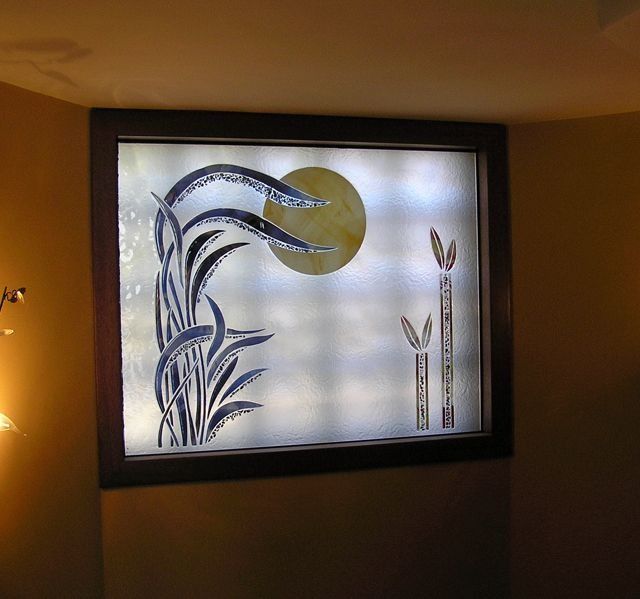 Una vidriera con la imagen de una planta y un sol.