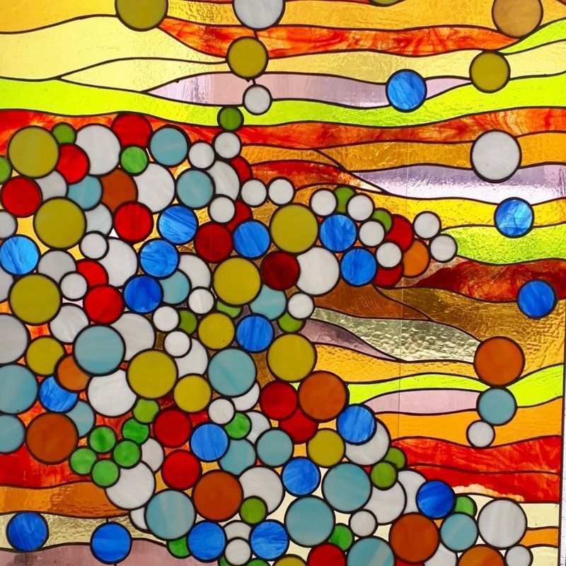 Una vidriera colorida con círculos y ondas.