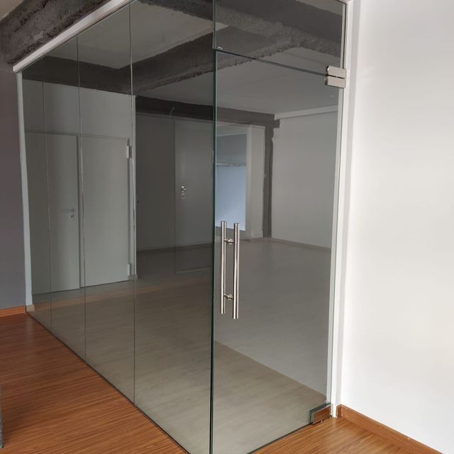 Una habitación vacía con una puerta de cristal y un suelo de madera.