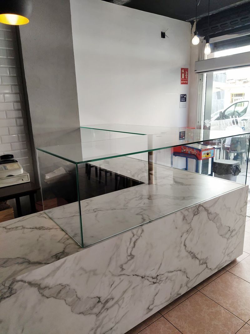Una encimera de mármol con una vitrina de cristal en un restaurante.