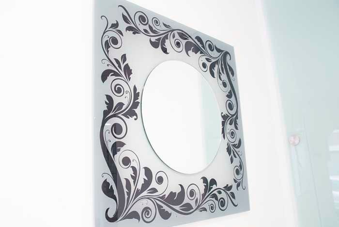 Un espejo cuadrado con un diseño floral.