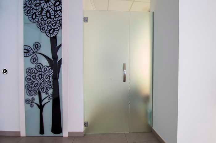 Una puerta de vidrio con una imagen de un árbol.