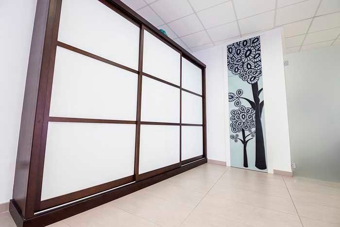 Una habitación con una puerta corrediza de vidrio y una imagen de árboles en la pared.