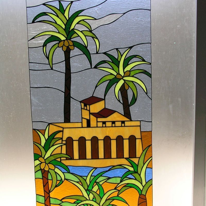 Una pintura de vidriera de una casa y palmeras.