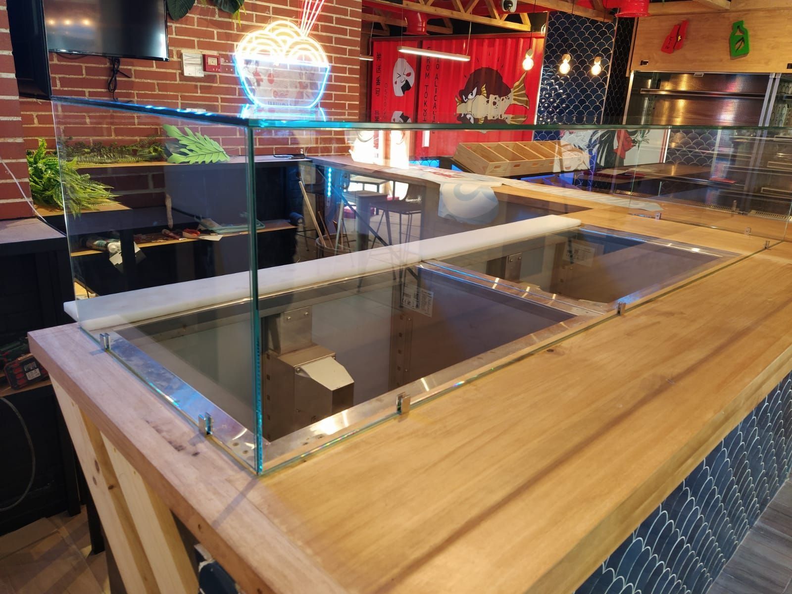 Un mostrador de madera con vitrina de cristal en un restaurante.