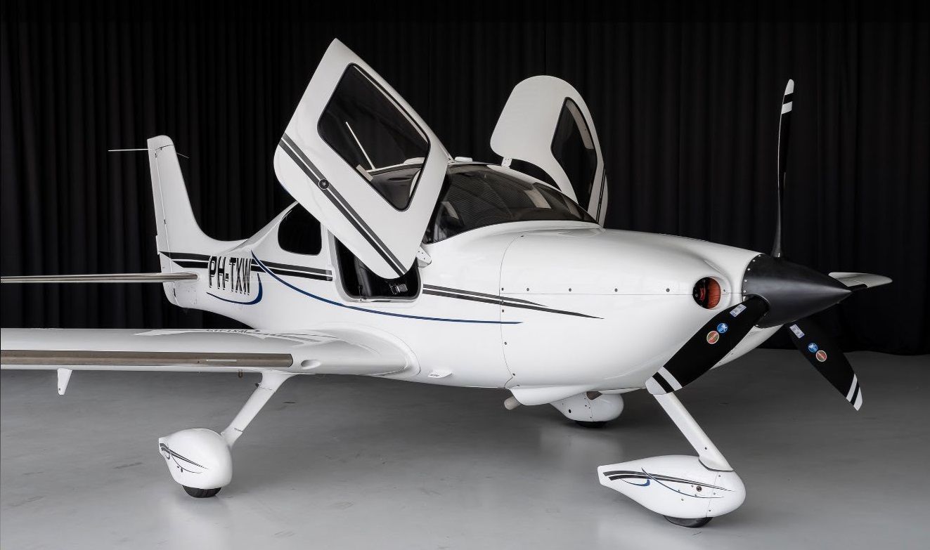 Un pequeño avión blanco con las puertas abiertas y las letras rnj en el costado.