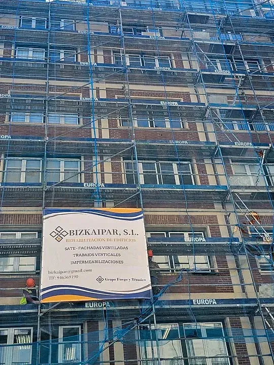 Un gran edificio en construcción con andamios y un cartel que dice rizamar sl