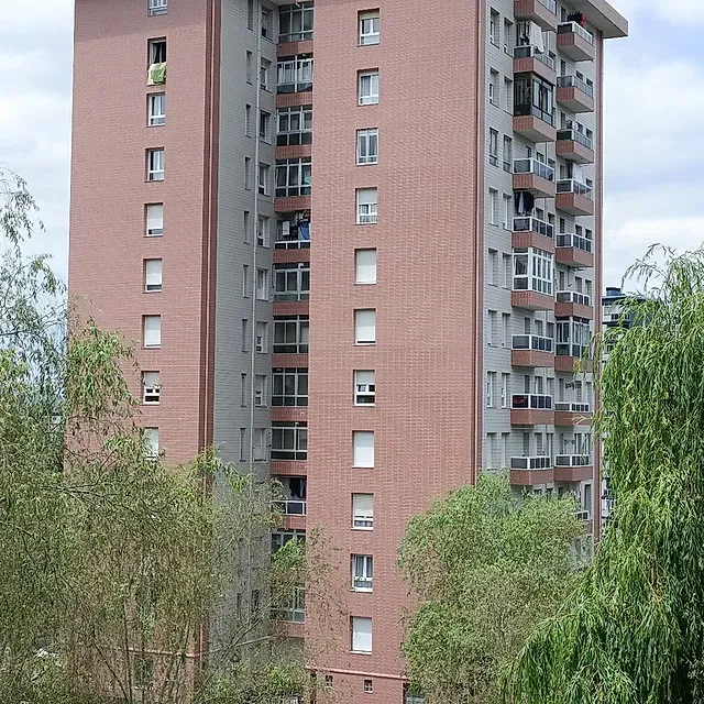 Un edificio alto de ladrillo con muchas ventanas y balcones.