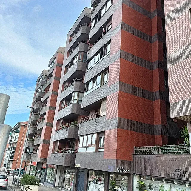 Un edificio alto con muchas ventanas y balcones.