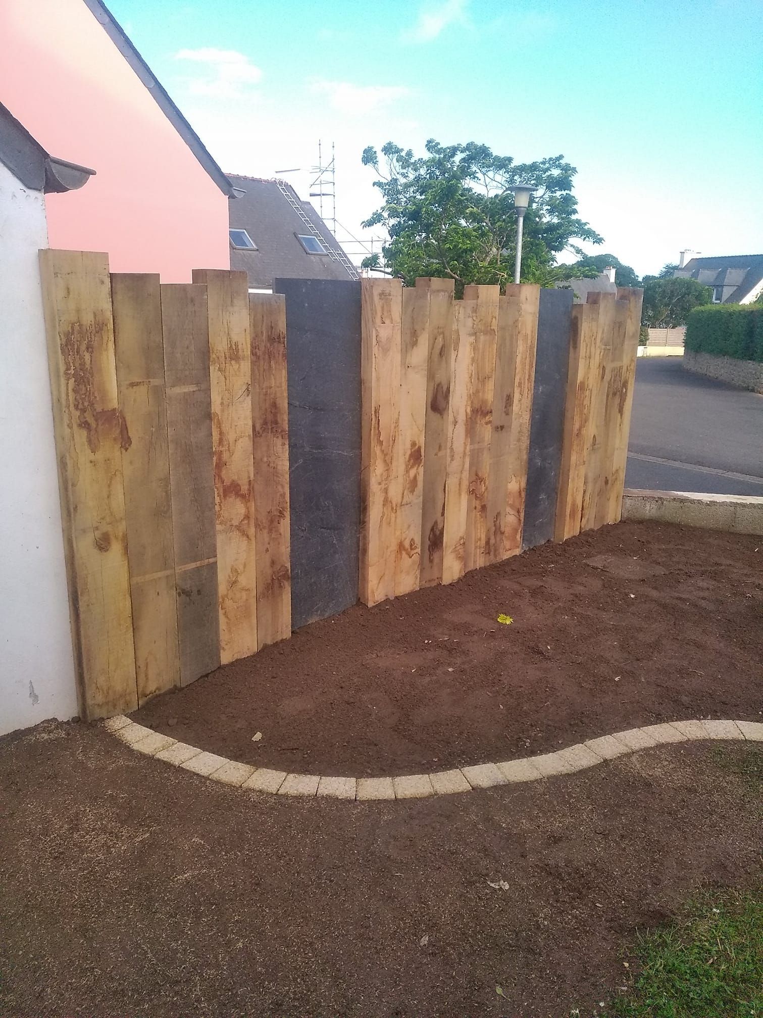 Clôture de traverses en chêne et palis d'ardoise.