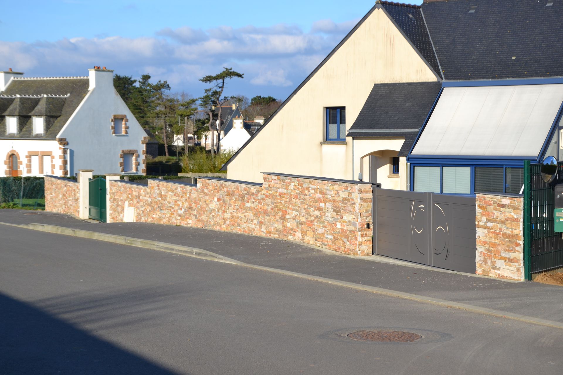 Muret en pierres avec portail gris