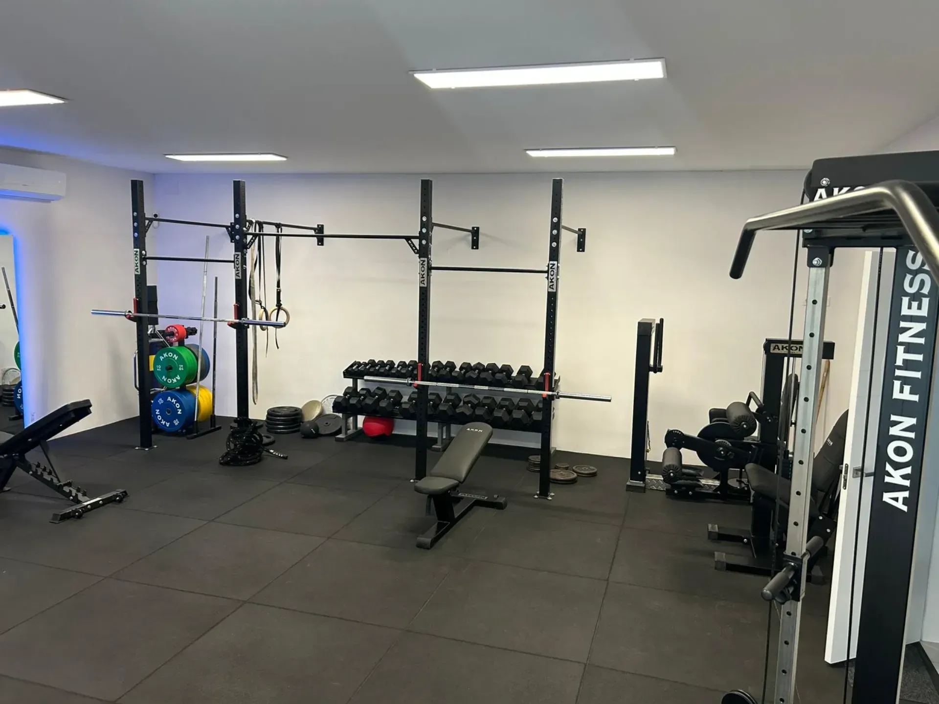 Un gimnasio con mucho equipamiento y una máquina que dice akon fitness.