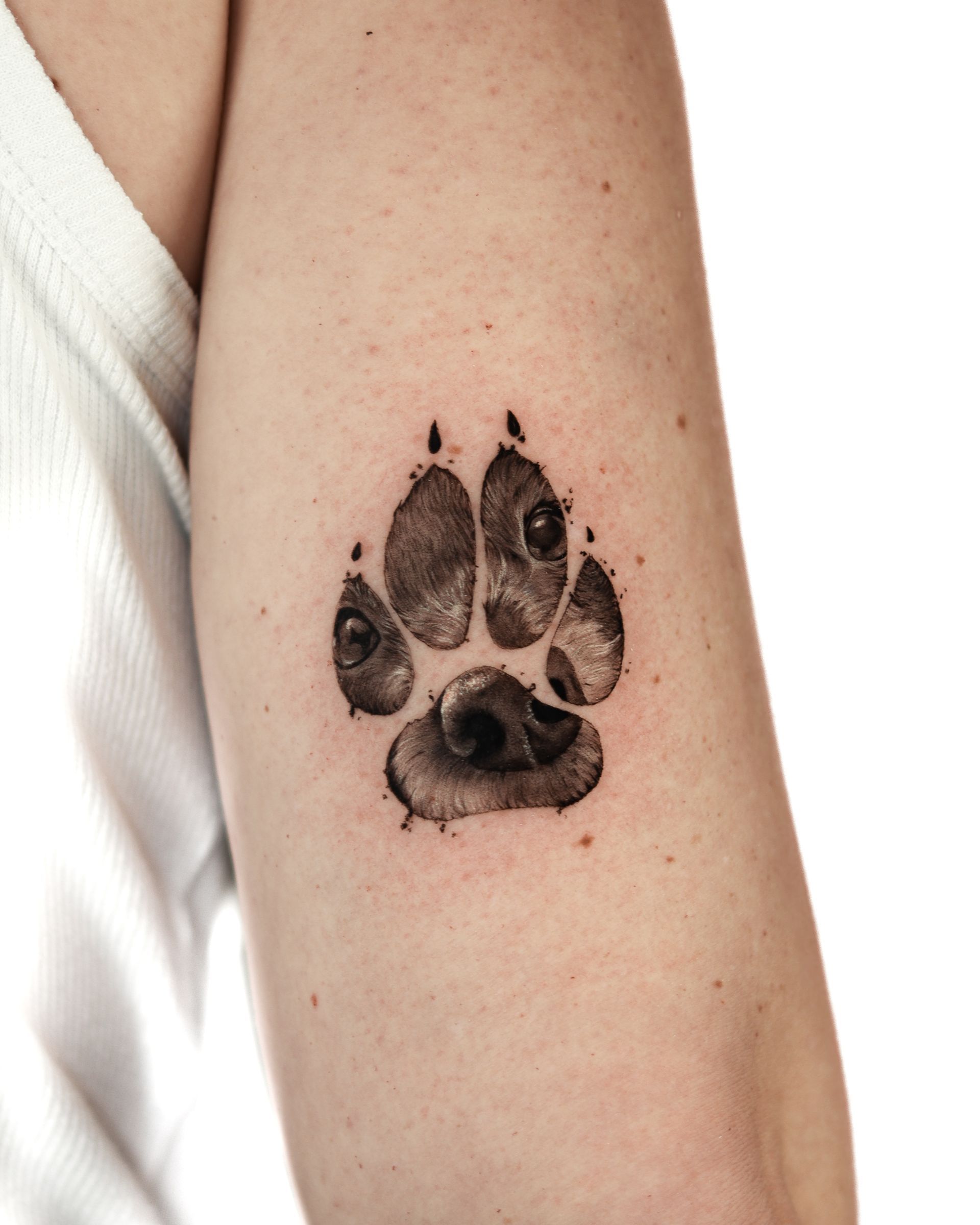 Una mujer tiene una imagen de una huella de pata en su brazo.