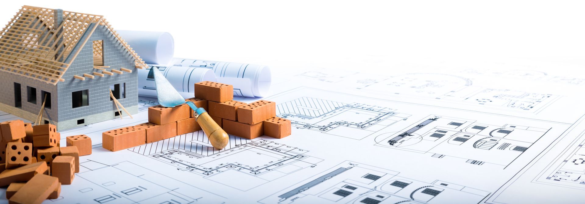 Maquette d'une petite maison avec des briques orange sur des plans architecturaux