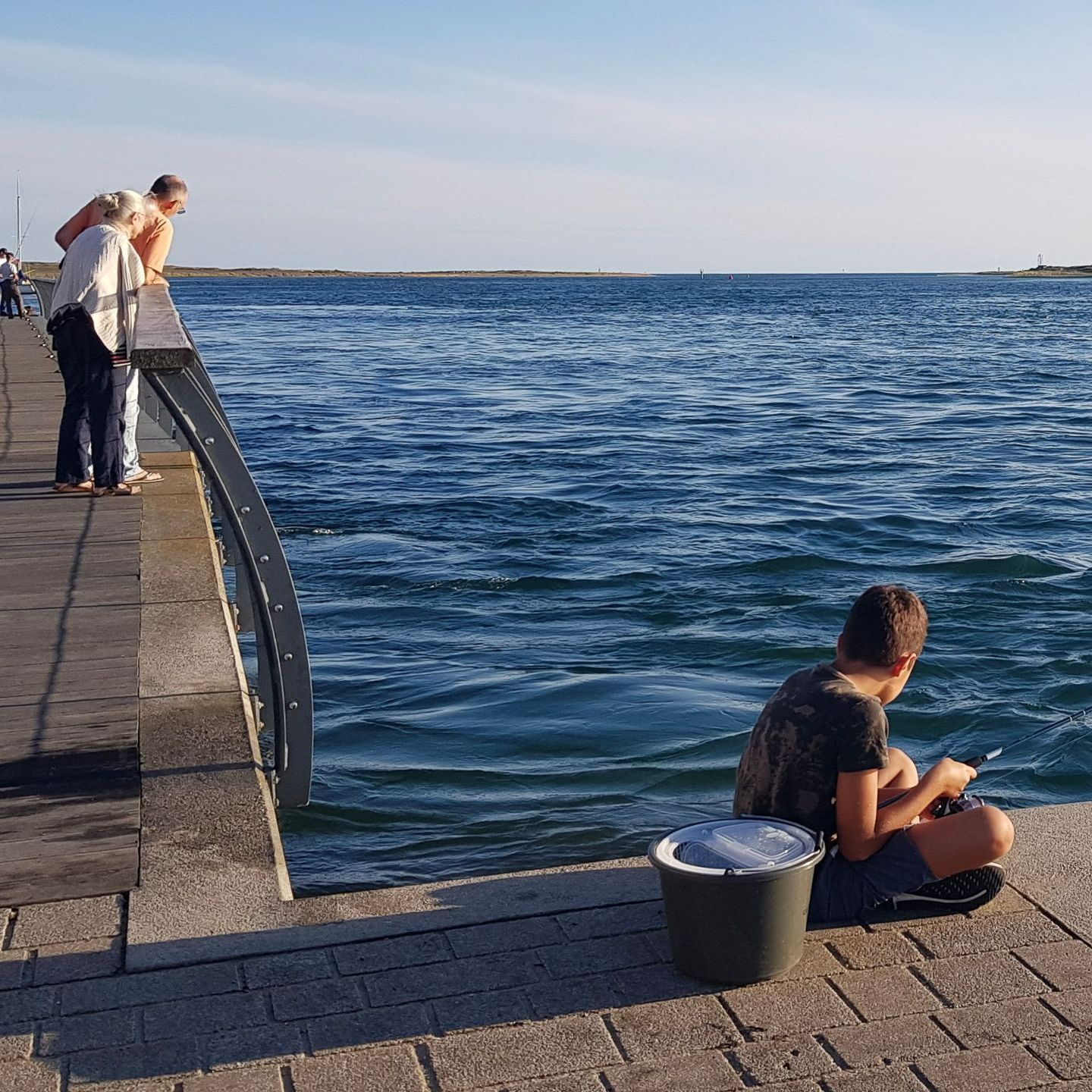 Un enfant pêche sur le port d'Étel