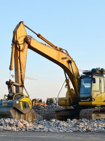Una excavadora amarilla está trabajando en un sitio de construcción.