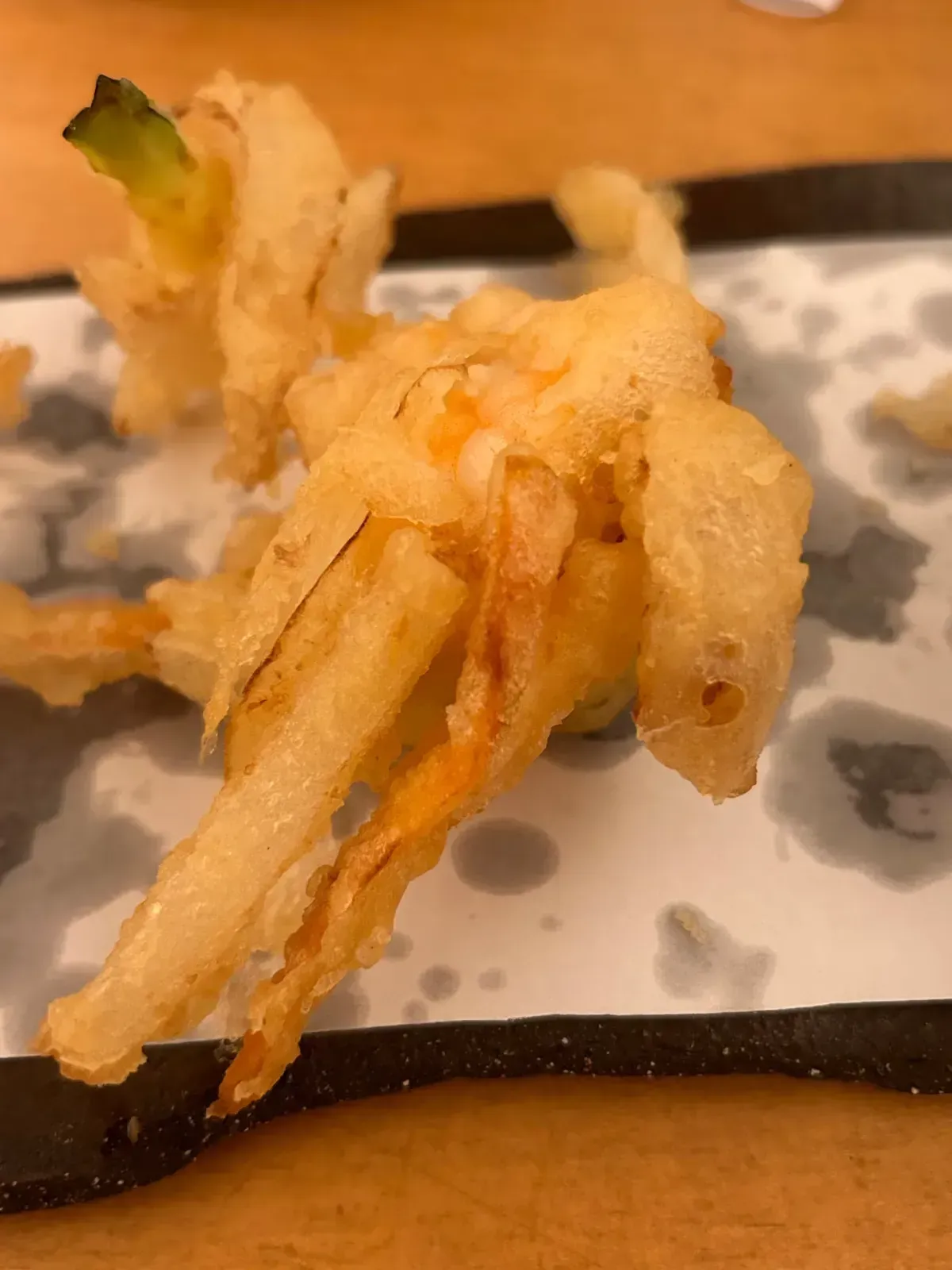 Verduras salteadas en tempura. Exterior dorado y crujiente con trozos visibles de verduras.