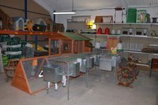 El interior de un almacén muestra diversos artículos para mascotas y aves de corral, incluyendo jaulas, comederos y recintos para animales pequeños.