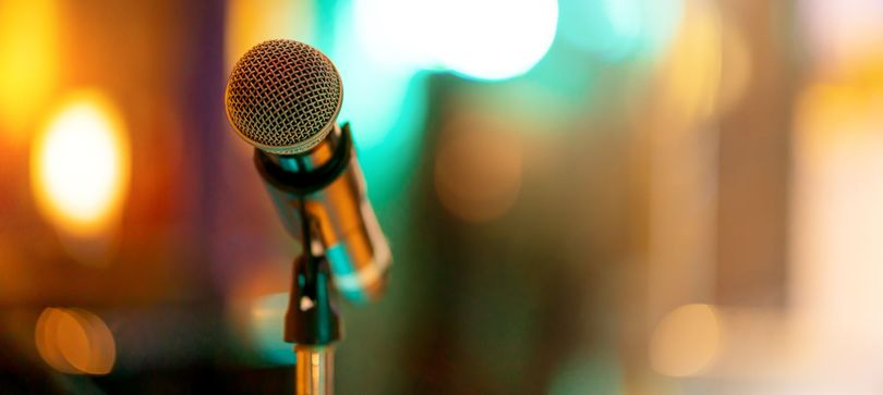 Microphone sur pied avec des lumières chaudes et floues en arrière-plan