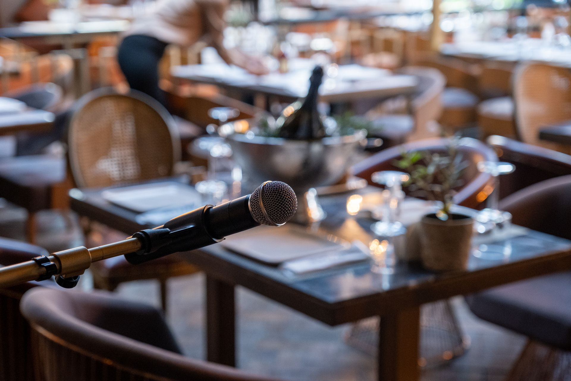 Microphone posé sur une table de café, avec en arrière-plan un intérieur de restaurant aux tons chauds et flous.