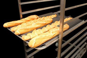 Hay tres hogazas de pan colocadas en una bandeja sobre una rejilla.