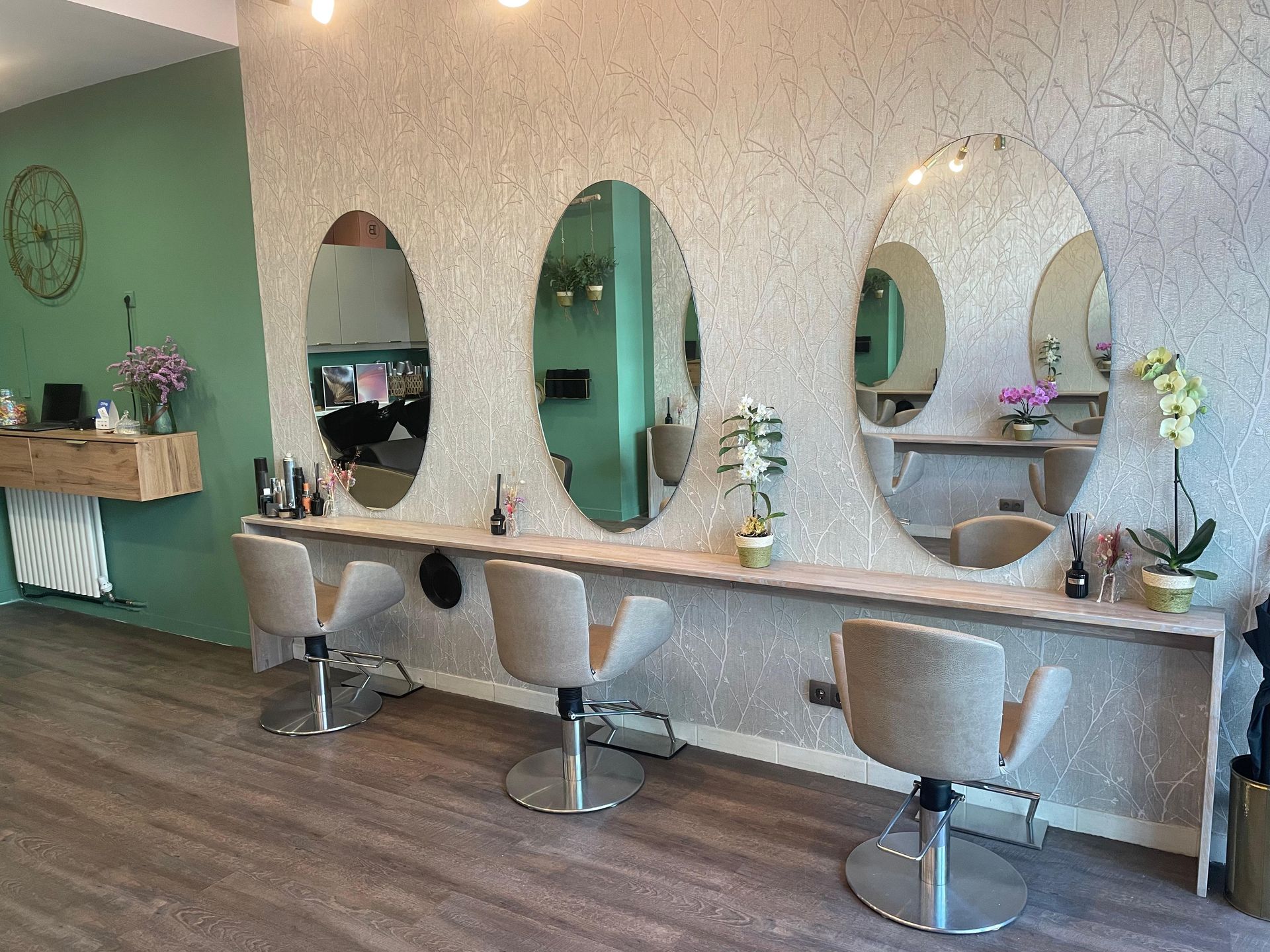 Ein Friseursalon mit drei Stühlen und drei Spiegeln.