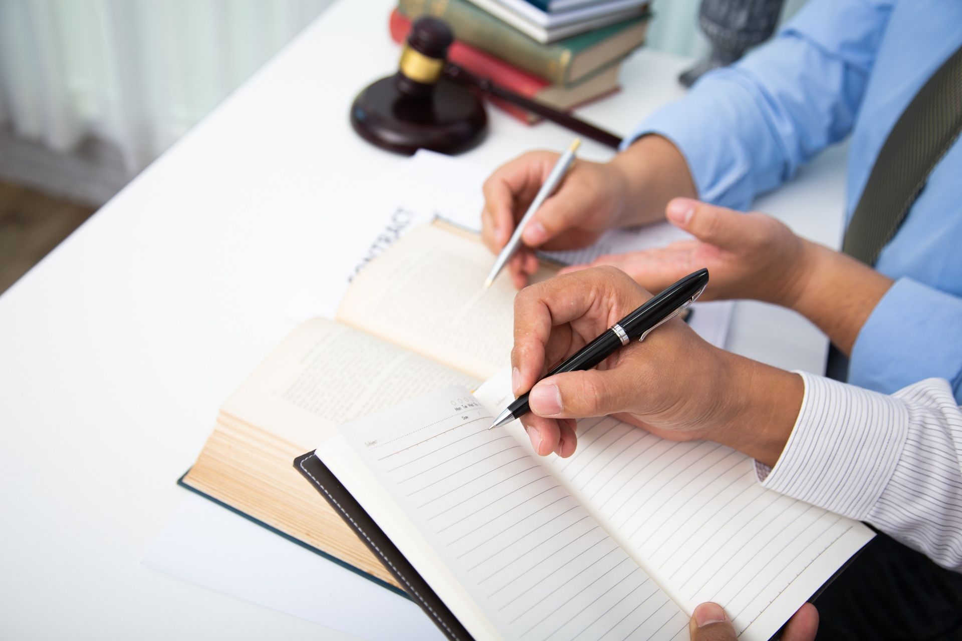 Una pareja está sentada en una mesa escribiendo en un cuaderno.