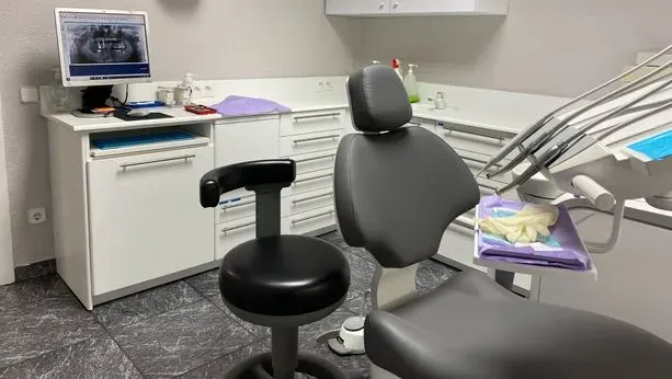 Un consultorio dental con un sillón dental y una computadora.