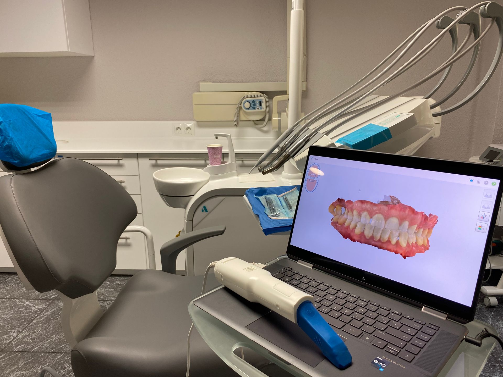 Una computadora portátil está sobre una mesa en un consultorio dental.