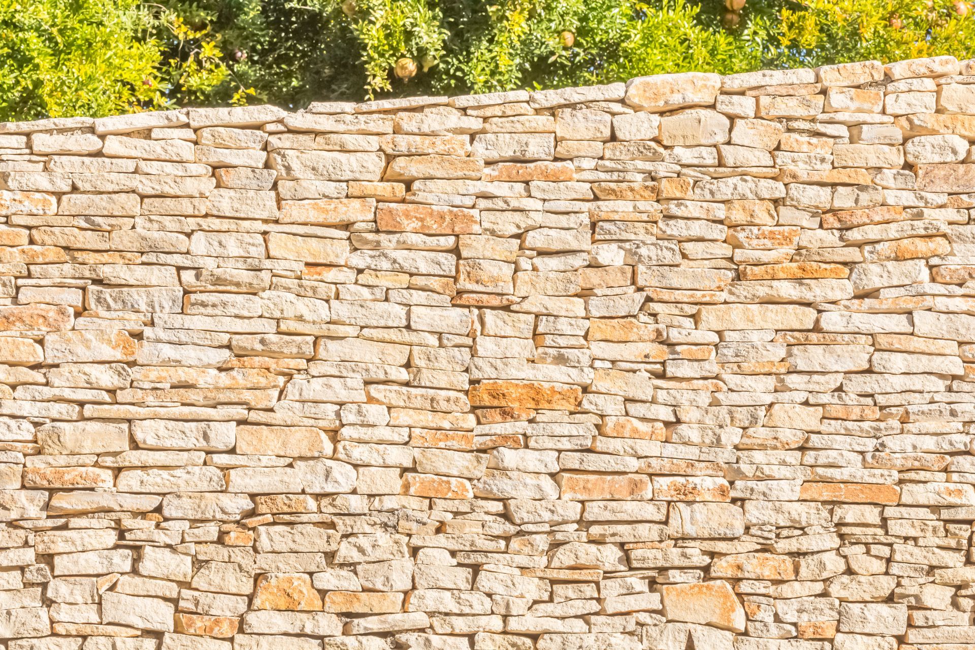 Mur en pierre à la texture rugueuse et de couleur beige.