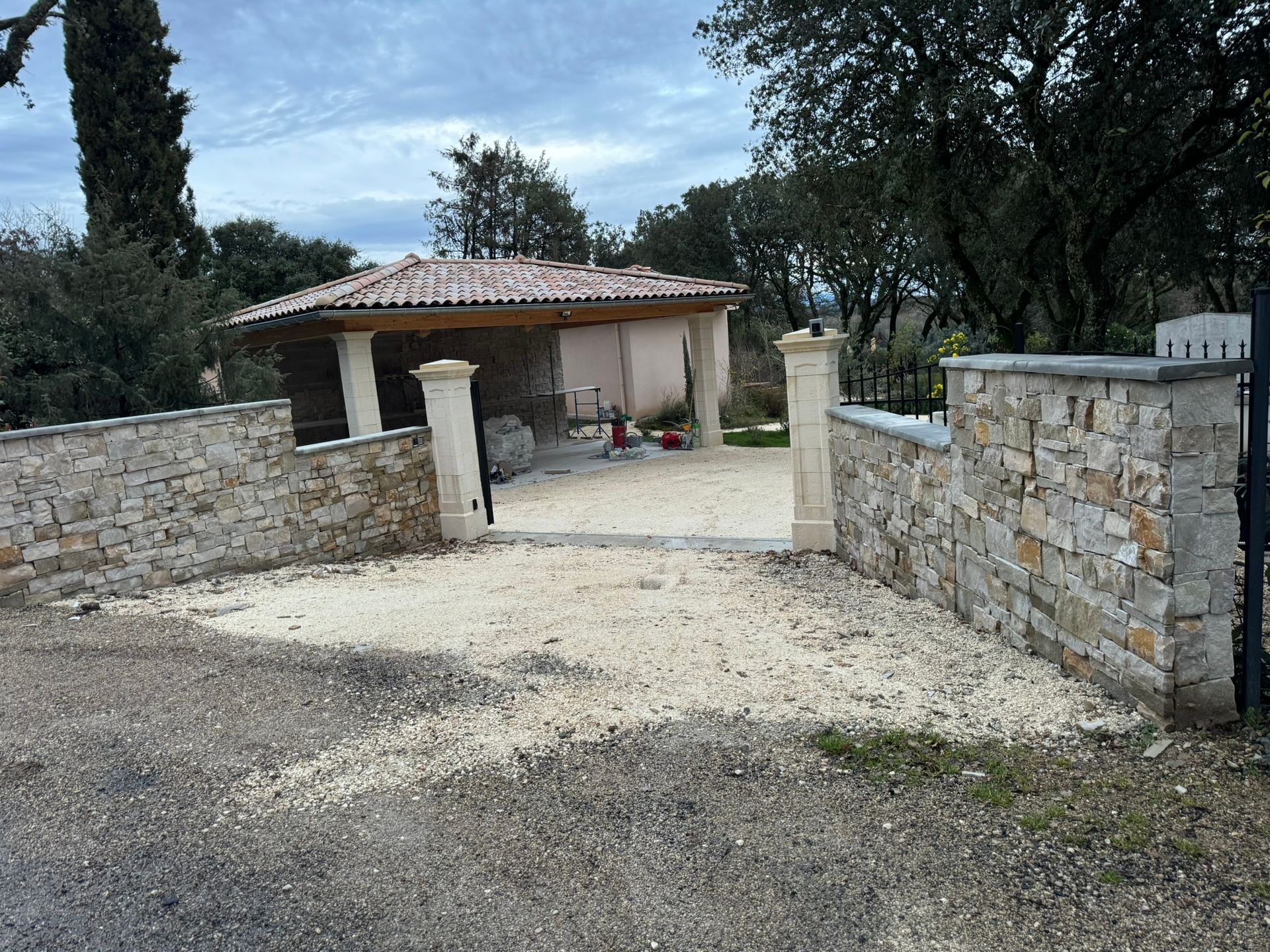 Mur en pierre de tailles et de formes variées, de couleur beige.