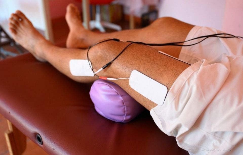 Nahaufnahme von Händen, die während einer Massage in den Rücken einer Person drücken; der Hintergrund ist verschwommen.