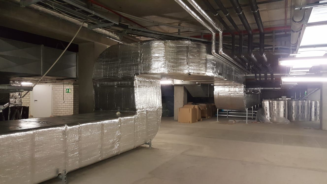 silberne Rohre verlaufen innen an einer Industrieanlage