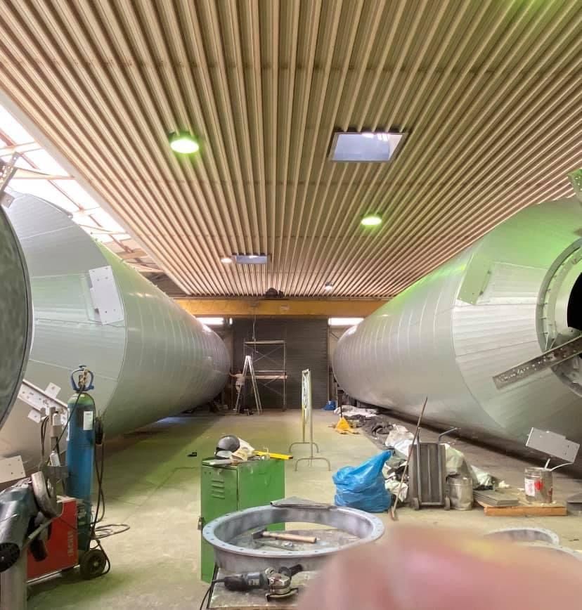 silberne Rohre verlaufen innen an einer Industrieanlage