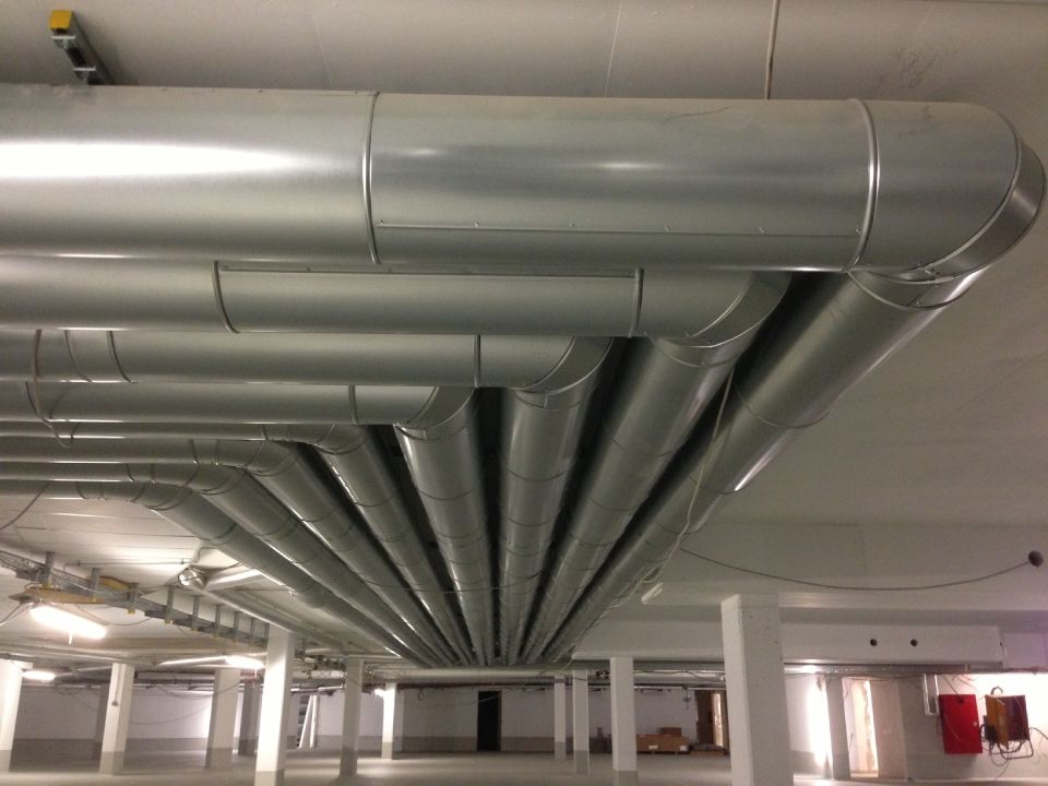 silberne Rohre verlaufen innen an einer Industrieanlage