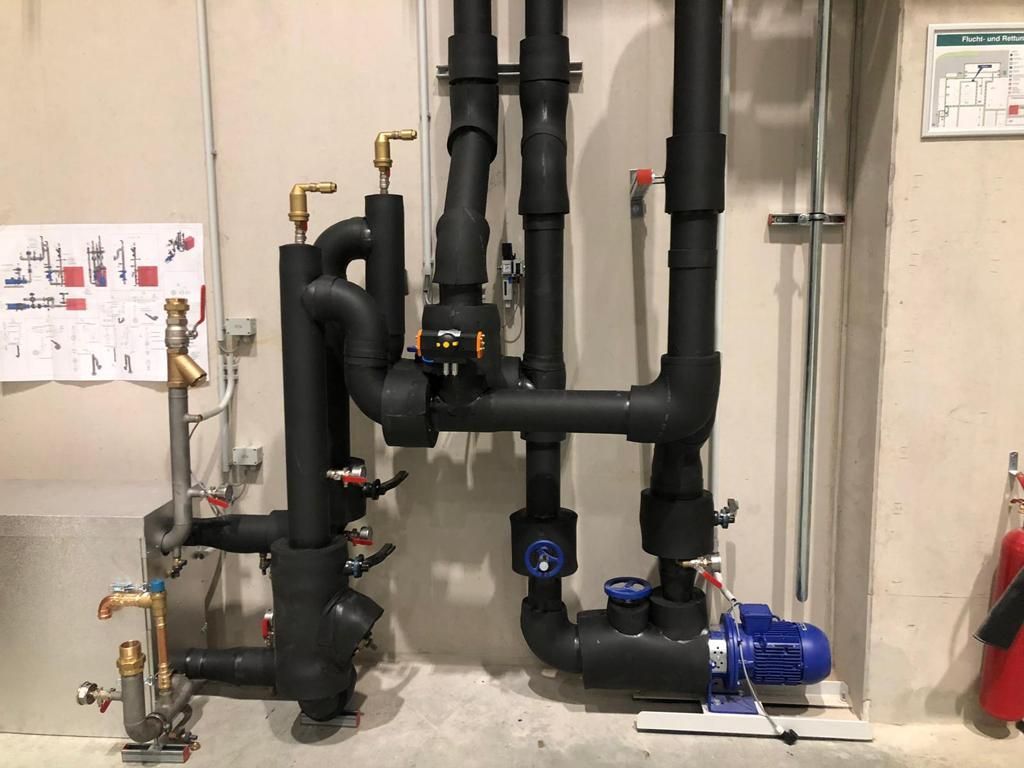 schwarze Rohre vor weißer Wand