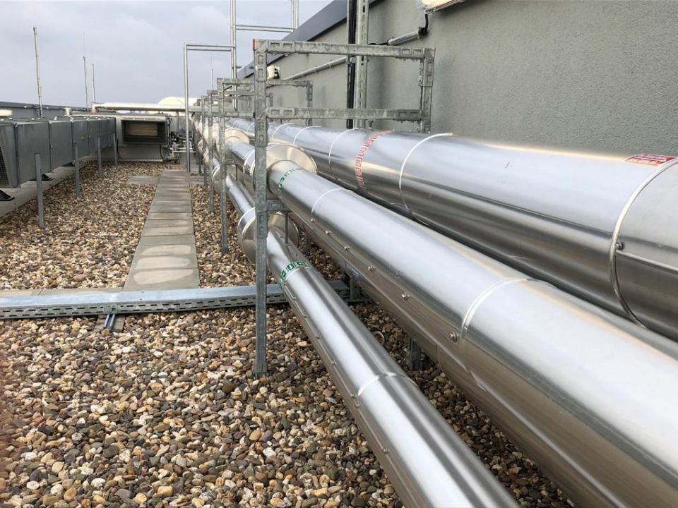 silberfarbene Rohre an der Außenwand eines Gebäudes