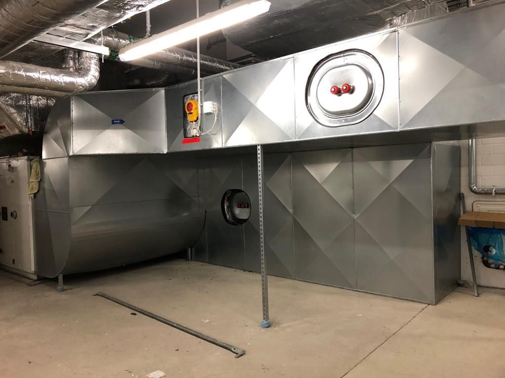 silberne Rohre verlaufen innen an einer Industrieanlage