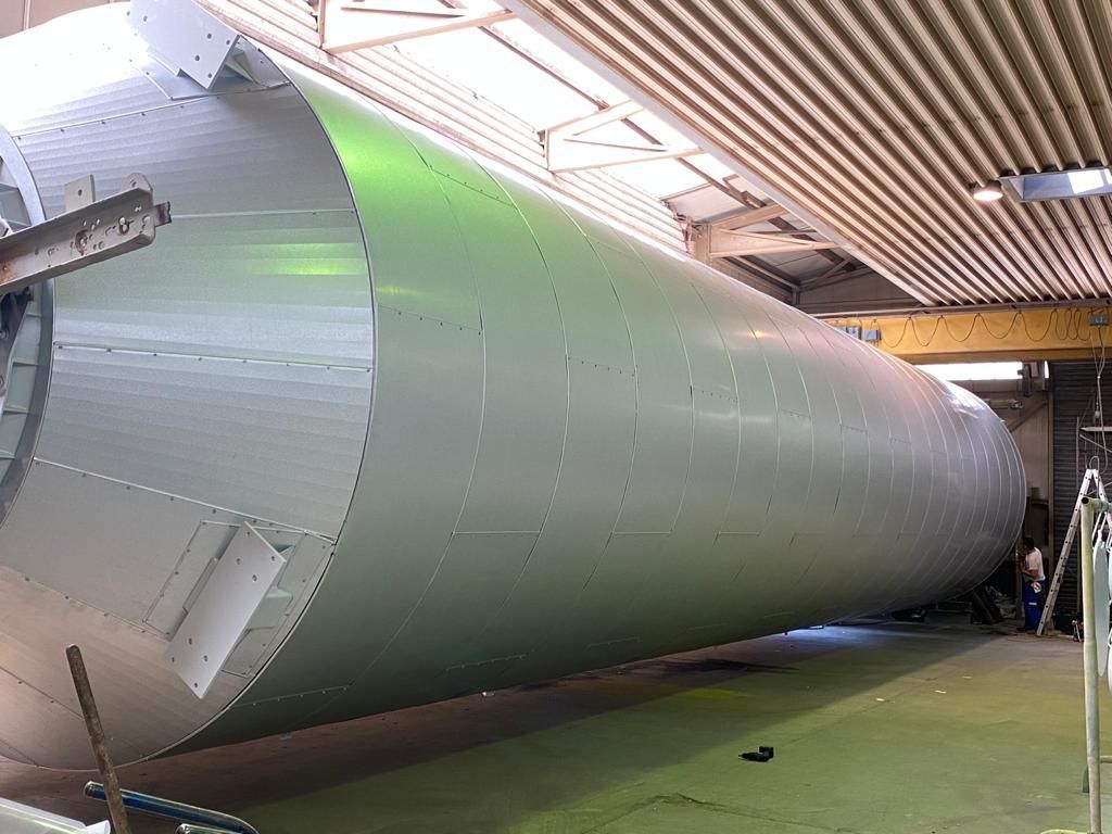 silberne Rohre verlaufen innen an einer Industrieanlage