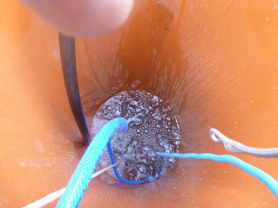 Rohr mit Wasser und blauen Kabeln