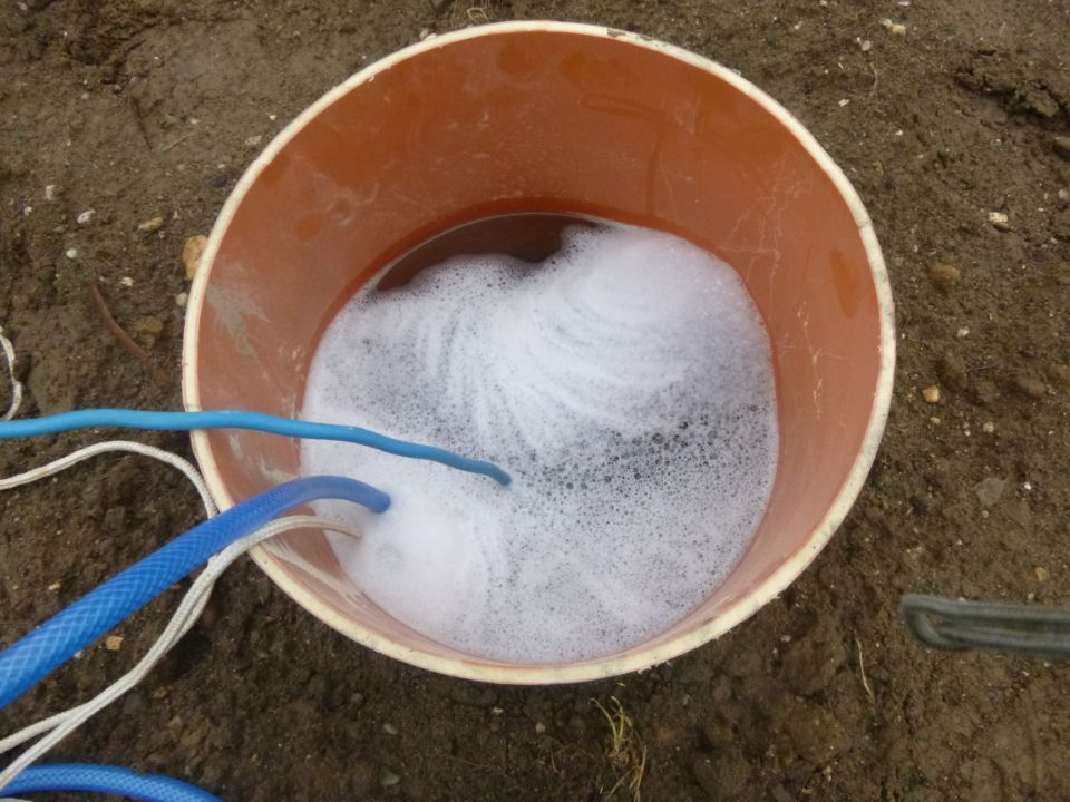 Eimer mit Flüssigkeit und blauen Kabeln